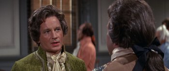 Movie still from “1776” (1972), directed by Peter H. Hunt – A man in a green jacket and a man in a brown jacket talking; Close Up shot, Over the shoulder angle