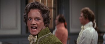 Movie still from “1776” (1972), directed by Peter H. Hunt – An old man with a beard and a green sweater; Close Up shot, Over the shoulder angle