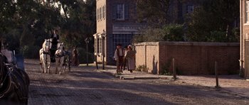 Movie still from “1776” (1972), directed by Peter H. Hunt – A couple of people standing next to each other on a sidewalk; Extreme Wide shot, High angle