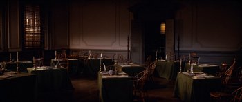Movie still from “1776” (1972), directed by Peter H. Hunt – A dining room filled with tables , chairs , candles and a fireplace; Wide shot, High angle