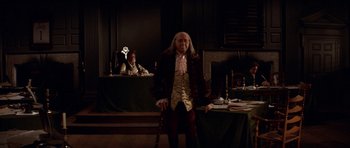Movie still from “1776” (1972), directed by Peter H. Hunt – A man standing in front of a table with candles on it; Wide shot, Low angle