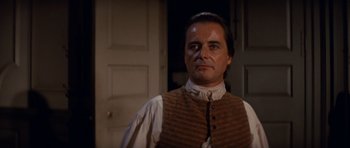 Movie still from “1776” (1972), directed by Peter H. Hunt – A person wearing a vest in a room; Close Up shot, Over the shoulder angle