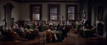 Movie still from “1776” (1972), directed by Peter H. Hunt – A group of people sitting at tables in a room; Extreme Wide shot, High angle