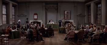 Movie still from “1776” (1972), directed by Peter H. Hunt – A group of people sitting around a table in a room; Extreme Wide shot, High angle