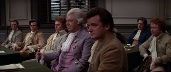 Movie still from “1776” (1972), directed by Peter H. Hunt – A group of men sitting next to each other in a room; Medium shot, High angle