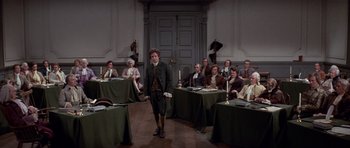 Movie still from “1776” (1972), directed by Peter H. Hunt – A group of people sitting around a room; Wide shot, High angle