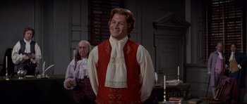 Movie still from “1776” (1972), directed by Peter H. Hunt – A man wearing a red vest and a white tie; Medium shot, Over the shoulder angle