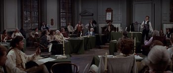 Movie still from “1776” (1972), directed by Peter H. Hunt – A group of people sitting at tables in a room; Wide shot, High angle