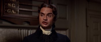 Movie still from “1776” (1972), directed by Peter H. Hunt – A person wearing a suit and tie; Close Up shot, Low angle