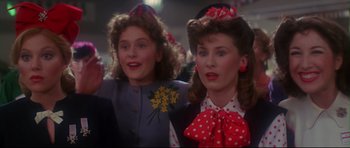 Movie still from “1941” (1979), directed by Steven Spielberg – Two young girls are dressed up and smiling for the camera; Close Up shot, Low angle