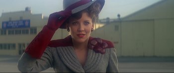 A woman wearing a hat and a red bow tie