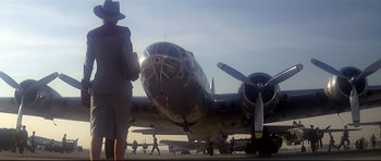 Movie still from “1941” (1979), directed by Steven Spielberg – An old airplane is parked on a runway; Wide shot, Low angle