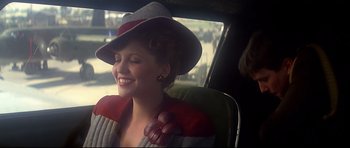 Movie still from “1941” (1979), directed by Steven Spielberg – A woman sitting in the back seat of a car wearing a hat; Close Up shot, Over the shoulder angle