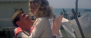 Movie still from “1941” (1979), directed by Steven Spielberg – A young girl with curly blonde hair is holding a pink tie; Medium shot, Low angle