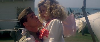 Movie still from “1941” (1979), directed by Steven Spielberg – A man and a woman in military uniforms kissing each other; Medium shot, Low angle