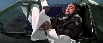Movie still from “1941” (1979), directed by Steven Spielberg – A man sitting in a chair with a napkin in front of him; Close Up shot, Overhead angle