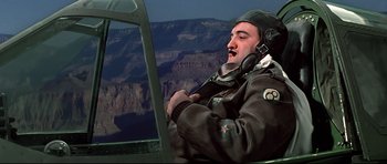 Movie still from “1941” (1979), directed by Steven Spielberg – A man in a military uniform sitting in the cockpit of an airplane; Medium shot, Low angle