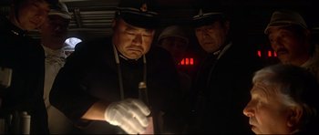 Movie still from “1941” (1979), directed by Steven Spielberg – A group of people in a dark room with a flashlight; Medium shot, Low angle