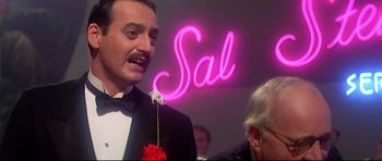 Movie still from “1941” (1979), directed by Steven Spielberg – A man in a tuxedo with a flower in his mouth; Close Up shot, Low angle