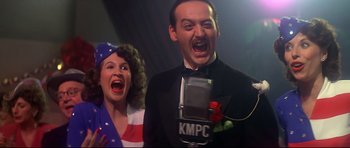 Movie still from “1941” (1979), directed by Steven Spielberg – A man and a woman singing into microphones in front of a microphone; Close Up shot, Low angle