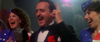 Movie still from “1941” (1979), directed by Steven Spielberg – A man in a suit and tie making a funny face; Close Up shot, Low angle