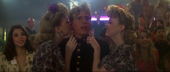 Movie still from “1941” (1979), directed by Steven Spielberg – A man in a military uniform with two other women; Close Up shot, Over the shoulder angle