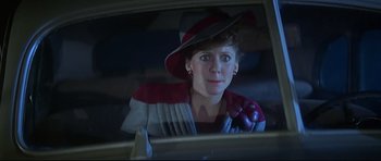 Movie still from “1941” (1979), directed by Steven Spielberg – A woman wearing a hat sitting in the back of a car; Close Up shot, Over the shoulder angle