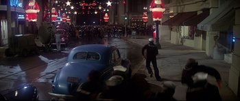 Movie still from “1941” (1979), directed by Steven Spielberg – A man walking down the street next to an old car; Extreme Wide shot, High angle