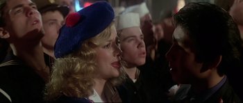 Movie still from “1941” (1979), directed by Steven Spielberg – A group of people in a room with one woman wearing a sailor's hat; Close Up shot, Over the shoulder angle