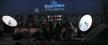 Movie still from “1941” (1979), directed by Steven Spielberg – A group of people standing in front of a building at night; Extreme Wide shot, Low angle