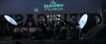 Movie still from “1941” (1979), directed by Steven Spielberg – A group of people standing next to each other in front of a building; Wide shot, Low angle