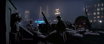Movie still from “1941” (1979), directed by Steven Spielberg – A group of people sitting in a field at night; Wide shot, Low angle