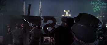 Movie still from “1941” (1979), directed by Steven Spielberg – A group of people standing next to each other in front of a bank of america sign at night; Wide shot, Low angle