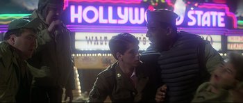 Movie still from “1941” (1979), directed by Steven Spielberg – Two young men standing next to each other in front of a hollywood sign; Medium shot, Low angle