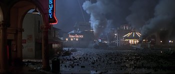 Movie still from “1941” (1979), directed by Steven Spielberg – Smoke billows from a building on the shore of a beach; Extreme Wide shot, High angle