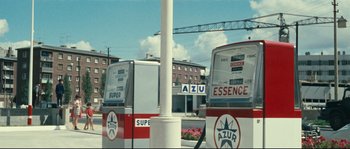 Movie still from “2 or 3 Things I Know About Her” (1967), directed by Jean-Luc Godard – A group of buses parked at a gas station; Extreme Wide shot, High angle