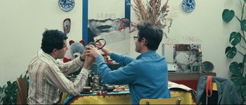 Movie still from “2 or 3 Things I Know About Her” (1967), directed by Jean-Luc Godard – A man holding a pair of scissors in his hands; Medium shot, Over the shoulder angle