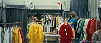 Movie still from “2 or 3 Things I Know About Her” (1967), directed by Jean-Luc Godard – Two women looking at clothes on a rack; Wide shot, High angle