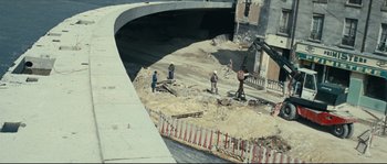 Movie still from “2 or 3 Things I Know About Her” (1967), directed by Jean-Luc Godard – A group of people working on a road; Extreme Wide shot, High angle
