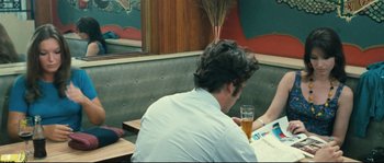 Movie still from “2 or 3 Things I Know About Her” (1967), directed by Jean-Luc Godard – A man sitting at a table in front of a glass of beer; Medium shot, Over the shoulder angle