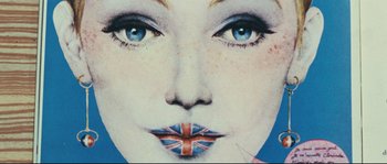 Movie still from “2 or 3 Things I Know About Her” (1967), directed by Jean-Luc Godard – A woman's face painted with the british flag; Extreme Close Up shot, Overhead angle