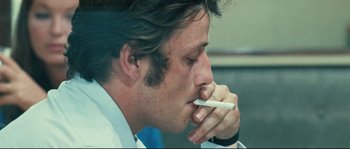 Movie still from “2 or 3 Things I Know About Her” (1967), directed by Jean-Luc Godard – A person holding a cigarette in his mouth; Close Up shot, Low angle