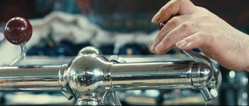 Movie still from “2 or 3 Things I Know About Her” (1967), directed by Jean-Luc Godard – A person is holding onto the handle of a metal bar; Extreme Close Up shot, Over the shoulder angle
