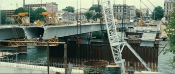 Movie still from “2 or 3 Things I Know About Her” (1967), directed by Jean-Luc Godard – A view of a construction site with a crane in the background; Extreme Wide shot, High angle
