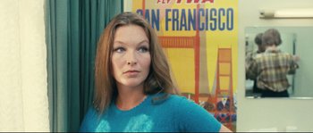 Movie still from “2 or 3 Things I Know About Her” (1967), directed by Jean-Luc Godard – A woman standing in front of an advertisement for an airline; Close Up shot, Low angle