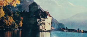 Movie still from “2 or 3 Things I Know About Her” (1967), directed by Jean-Luc Godard – An old castle sits on the edge of a body of water; Extreme Wide shot, High angle