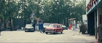 Movie still from “2 or 3 Things I Know About Her” (1967), directed by Jean-Luc Godard – A group of people standing next to cars on a street; Extreme Wide shot, High angle