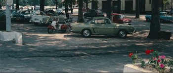 Movie still from “2 or 3 Things I Know About Her” (1967), directed by Jean-Luc Godard – An old car parked on the side of the street; Extreme Wide shot, High angle