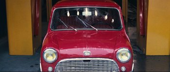 Movie still from “2 or 3 Things I Know About Her” (1967), directed by Jean-Luc Godard – The front of an old red car; Close Up shot, High angle