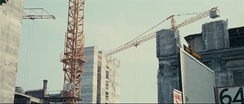 Movie still from “2 or 3 Things I Know About Her” (1967), directed by Jean-Luc Godard – A crane is in front of some buildings; Extreme Wide shot, Low angle